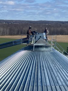 sayre farms construction crew on top of 75 foot grain bin in orwell ohio